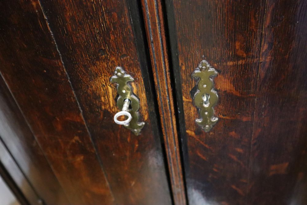 A George III oak bow-fronted hanging corner cupboard